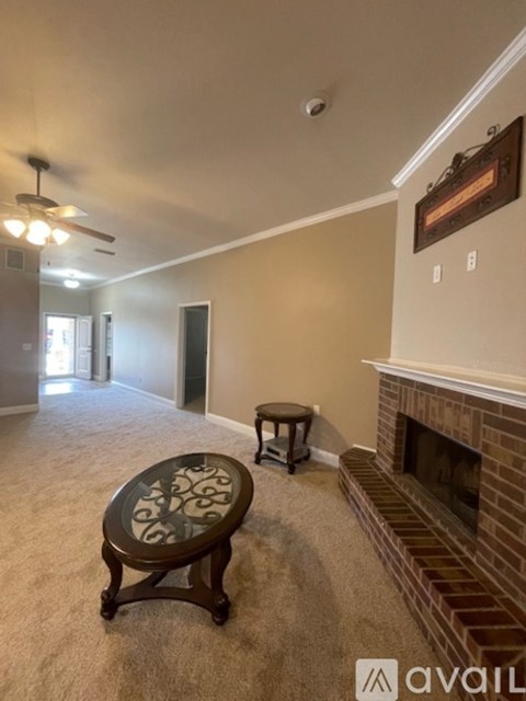 A living room with a fireplace and a ceiling fan.
