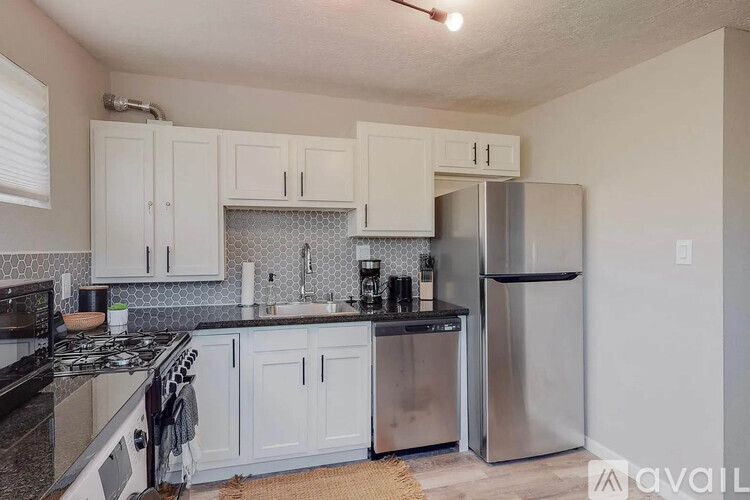 A kitchen with white cabinets and a black stove top.