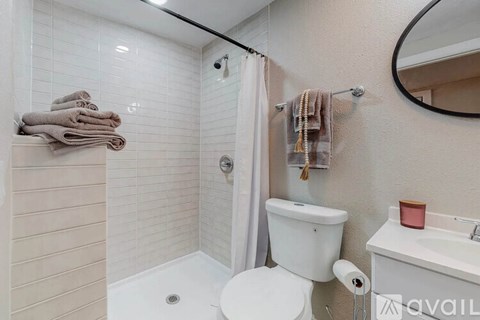 A bathroom with a toilet, sink, and shower.