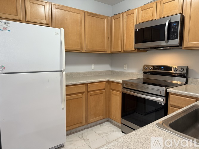 A kitchen with wooden cabinets and a white refrigerator.