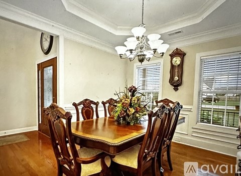 A dining room with a wooden table and chairs.