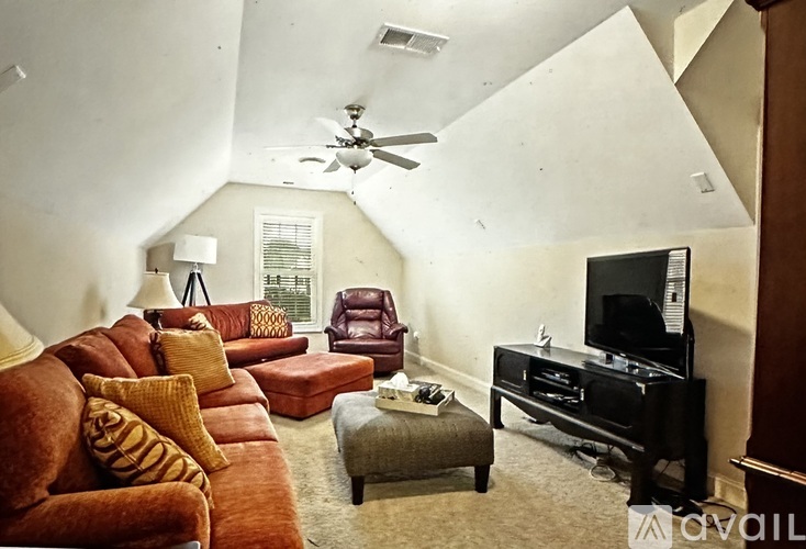 A living room with a brown couch and a television.