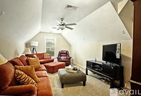 A living room with a brown couch and a television.