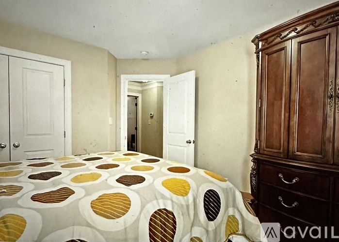 A bedroom with a bed, wardrobe and cupboard.