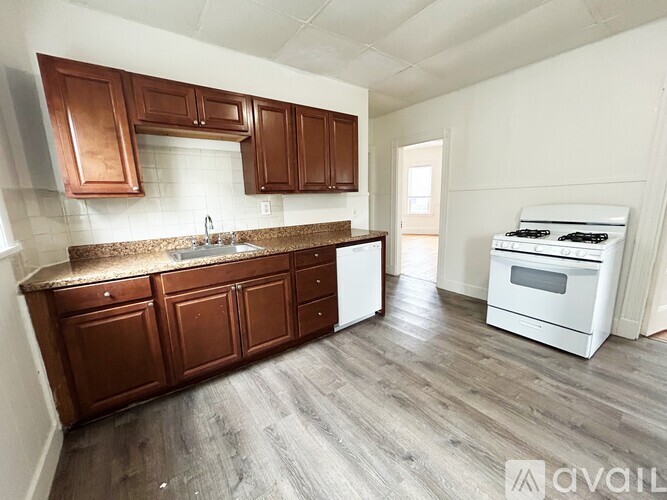 A kitchen with brown cabinets and a white stove top oven.