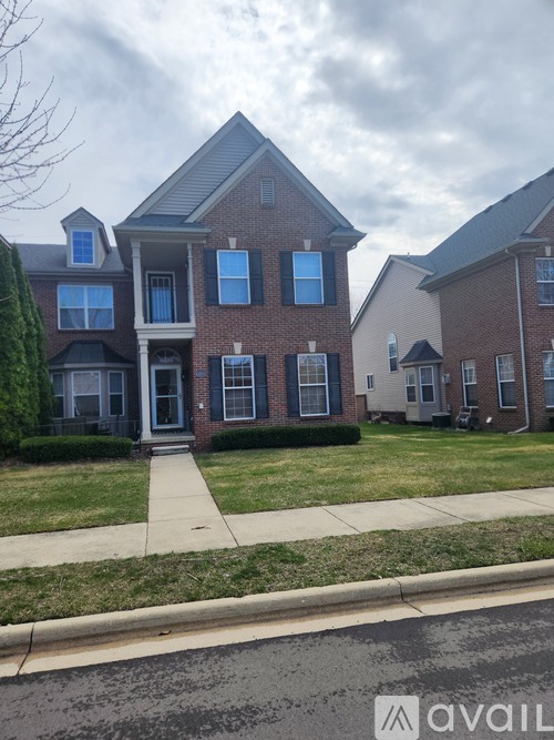 A row of houses with the first one having a red brick facade.