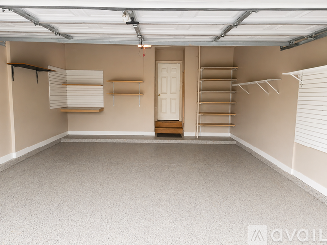 A spacious garage with a door and shelves.