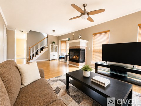 A living room with a brown couch and a black television.