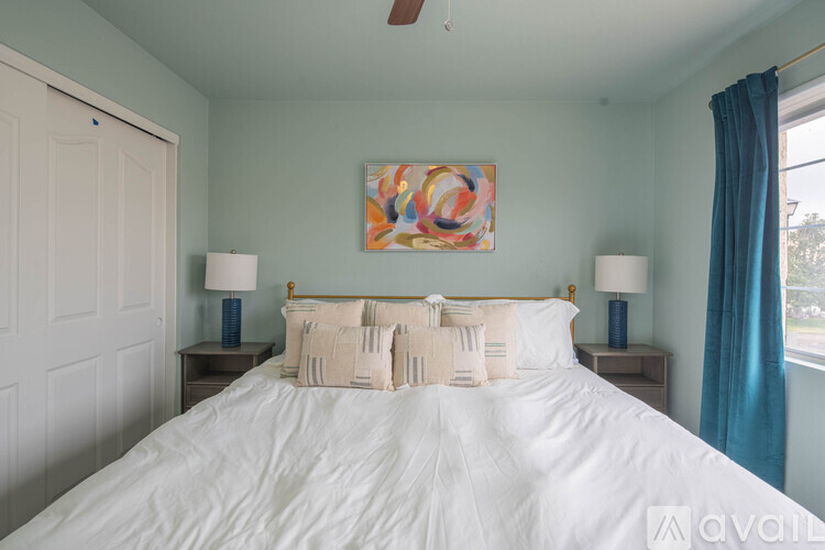 A bedroom with a large bed and a painting on the wall.