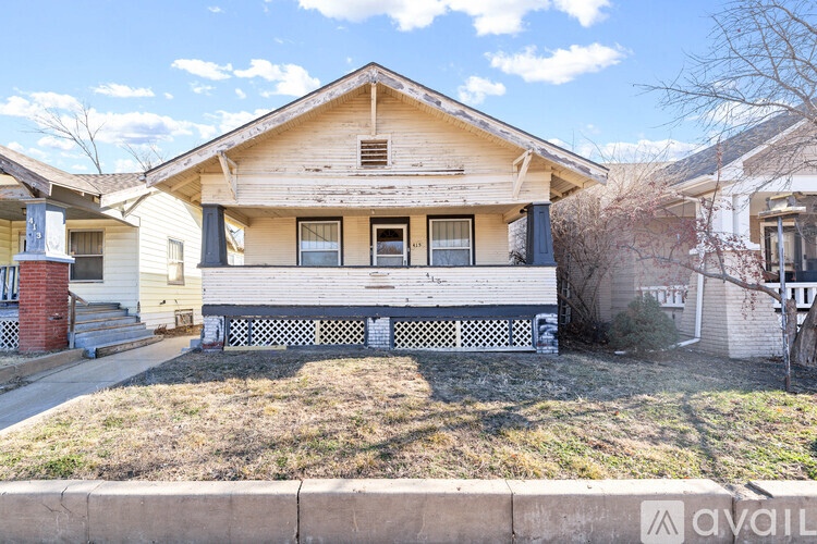 A house with a front porch and a small yard.