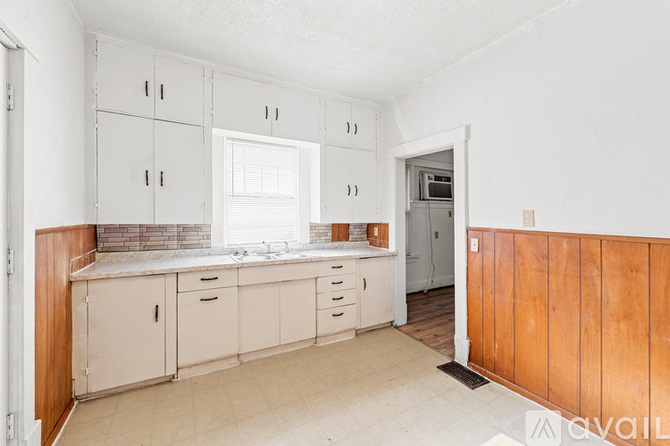 A kitchen with white cabinets and a wooden counter.