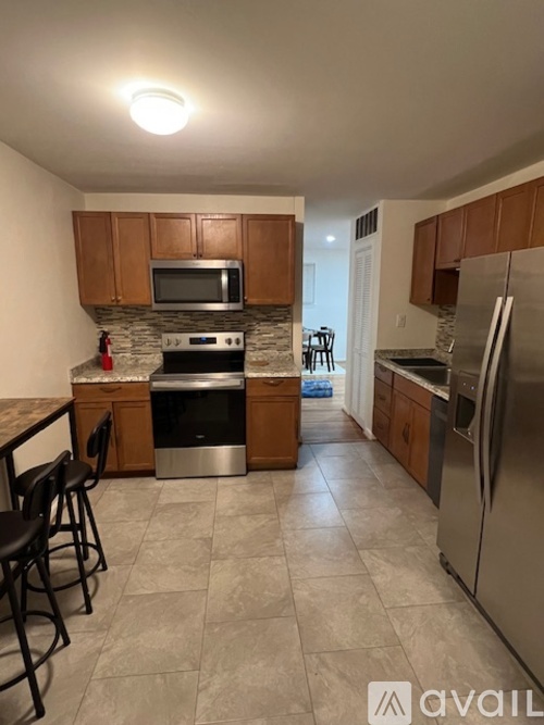 A kitchen with wooden cabinets and a stone backsplash.