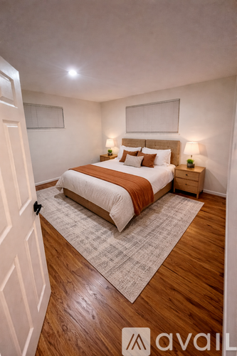 A bedroom with a bed, nightstands, and a rug.