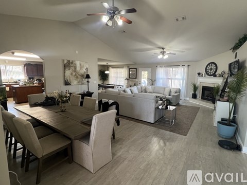 A spacious living room with a dining table and chairs.