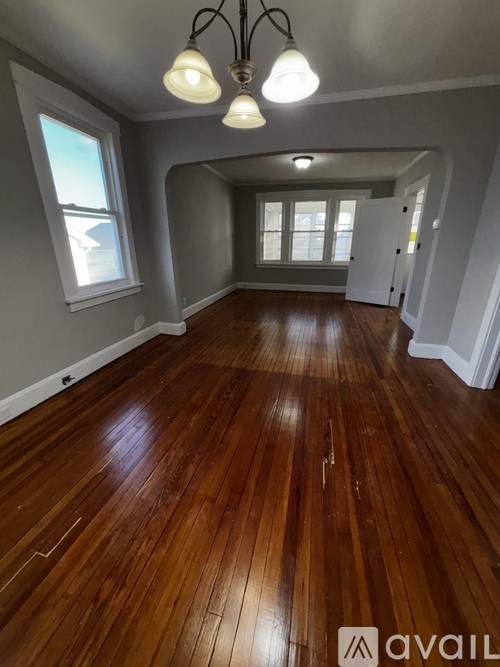 A room with wooden floors and a chandelier.