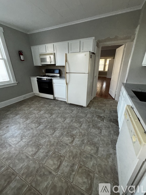 A kitchen with a white fridge, microwave, and stove top oven.