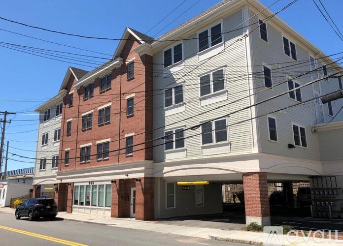 A two story building with a red brick bottom and white top.