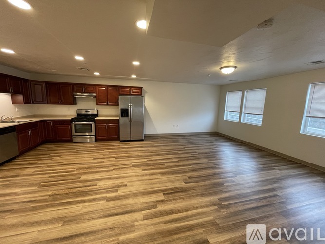 A kitchen with wooden floors and a refrigerator.