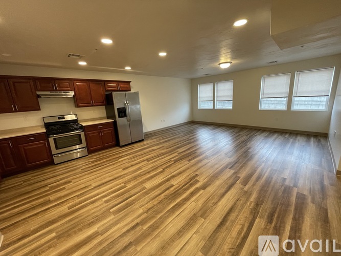 A kitchen with wooden floors and a refrigerator.