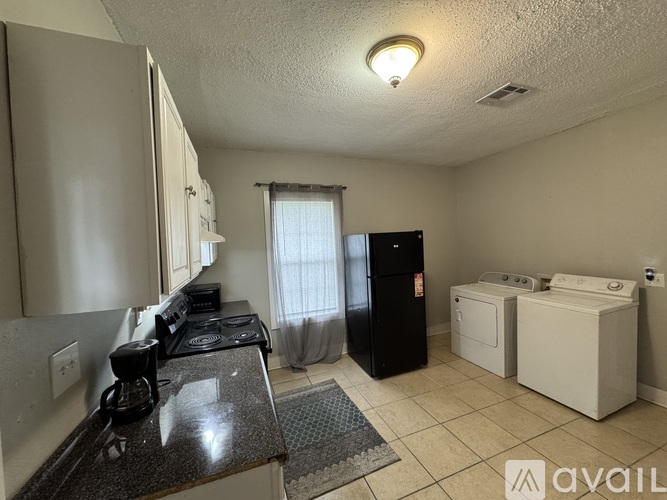 A kitchen with black granite countertops and white appliances.