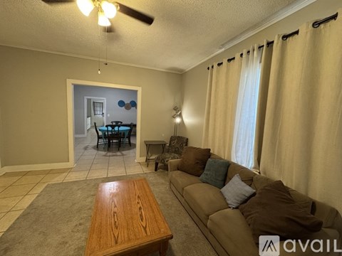 A living room with a brown couch and a wooden coffee table.