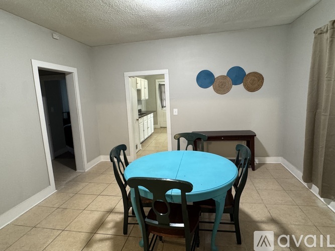 A dining room with a blue table and chairs.
