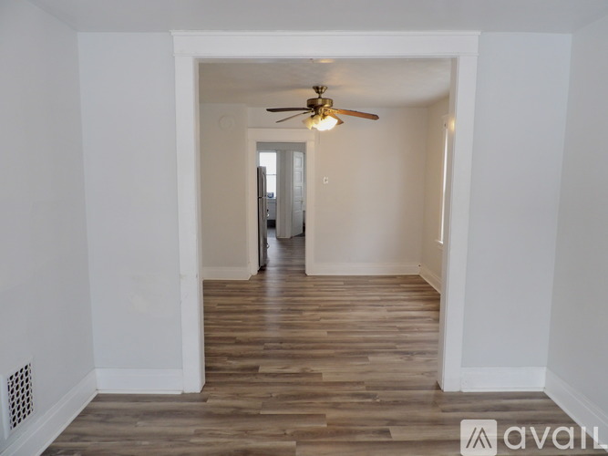 A room with wooden flooring and a ceiling fan.