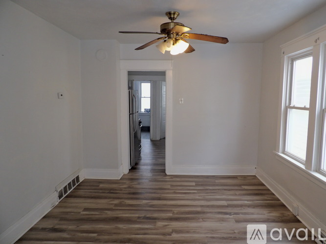 A room with wooden floors and a ceiling fan.