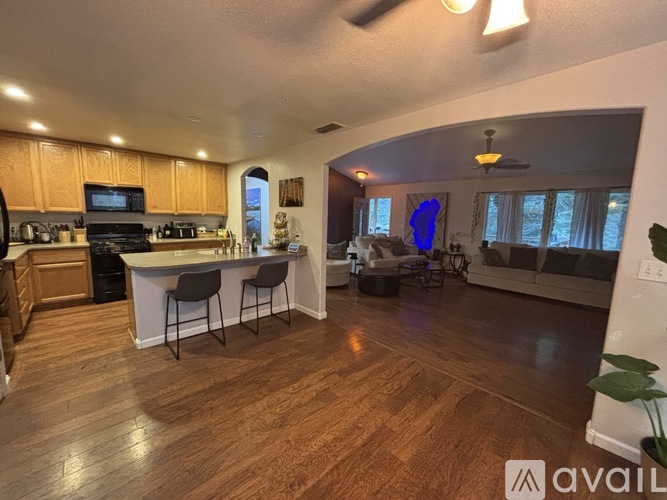 A kitchen with wooden floors and a white island in the middle.