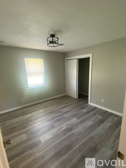 A room with wooden flooring and a ceiling fan.
