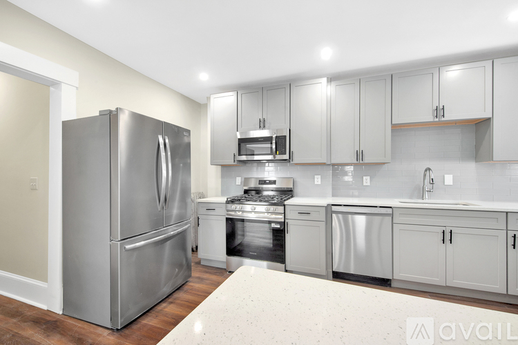 A modern kitchen with stainless steel appliances and white cabinets.