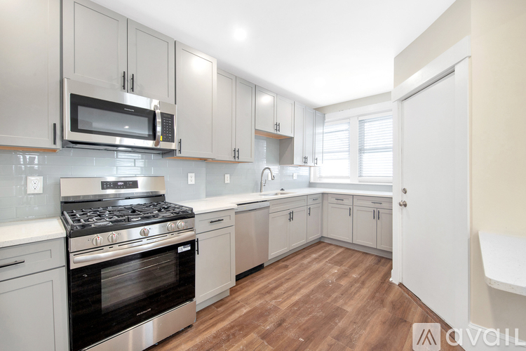 A kitchen with a stove, oven, microwave, and cabinets.