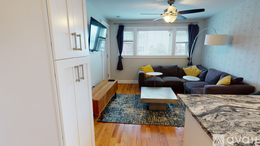 A living room with a couch, a coffee table, and a ceiling fan.