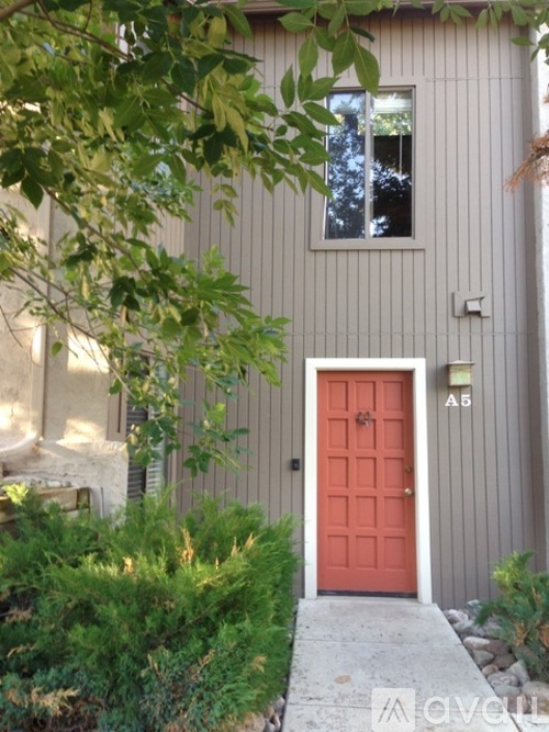 A red door is on the side of a house.