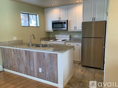 A kitchen with a wooden island and stainless steel appliances.