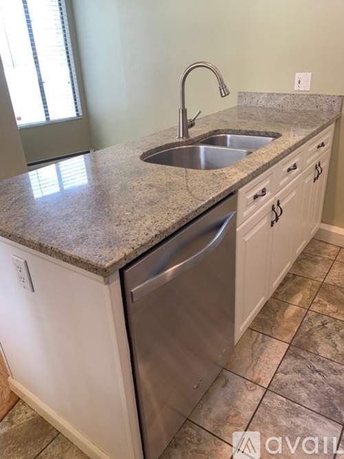 A kitchen with a granite countertop and stainless steel appliances.