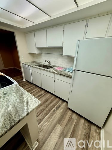A kitchen with white cabinets and a marble countertop.