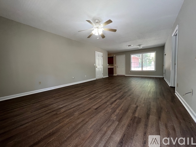 A room with wooden flooring and a ceiling fan.