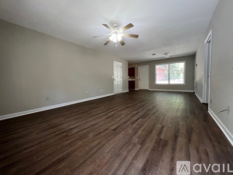 A room with wooden flooring and a ceiling fan.