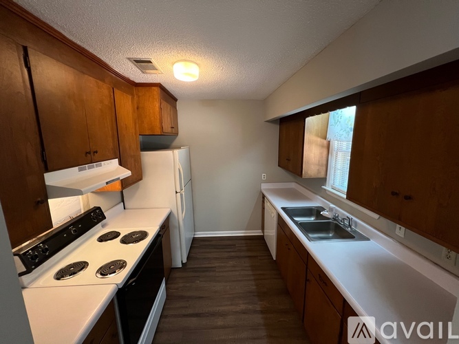 A kitchen with wooden cabinets and a white stove top oven.