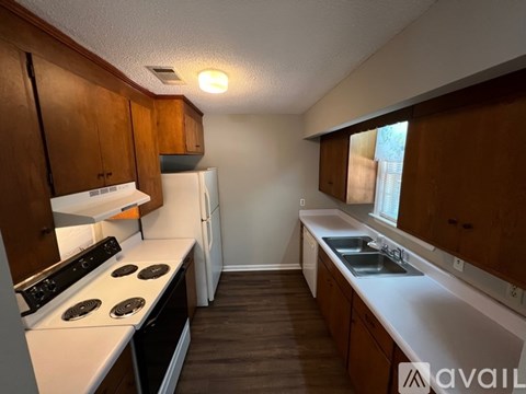 A kitchen with wooden cabinets and a white stove top oven.