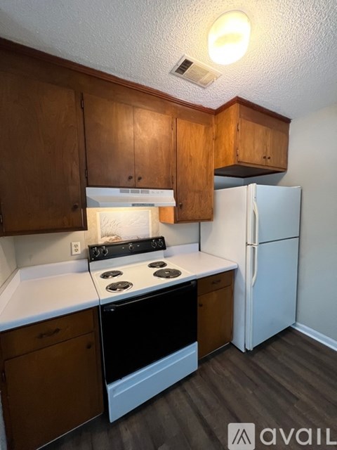 A kitchen with wooden cabinets and a black stove top oven.