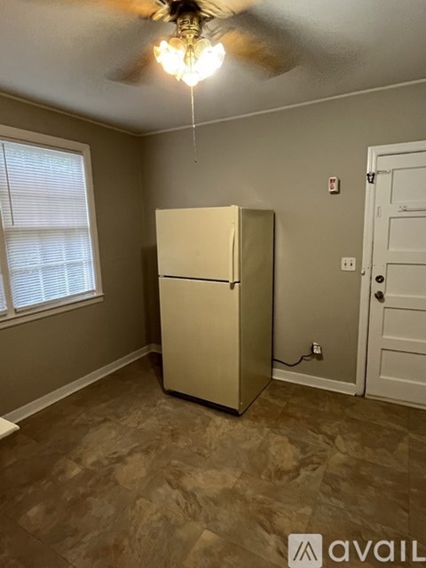 A room with a beige refrigerator and a ceiling fan.