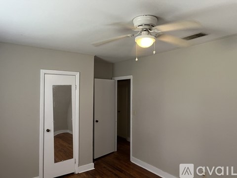 A room with a ceiling fan and two doors.