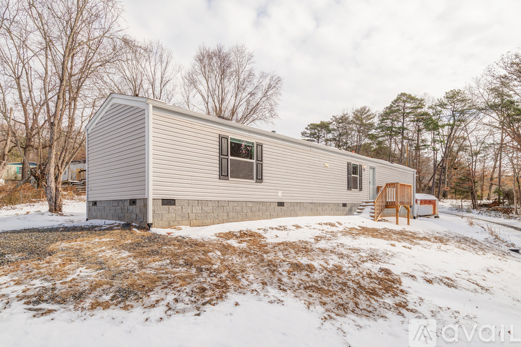 A modern house with a grey exterior stands in a snowy landscape.