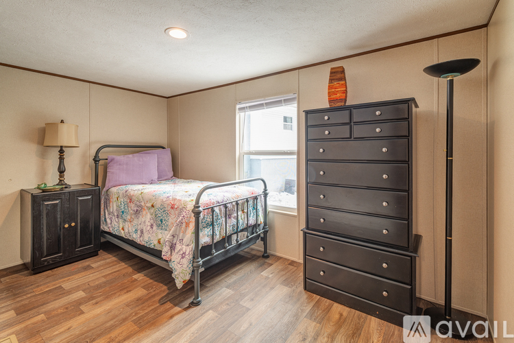 A bedroom with a bed, dresser, and nightstand.