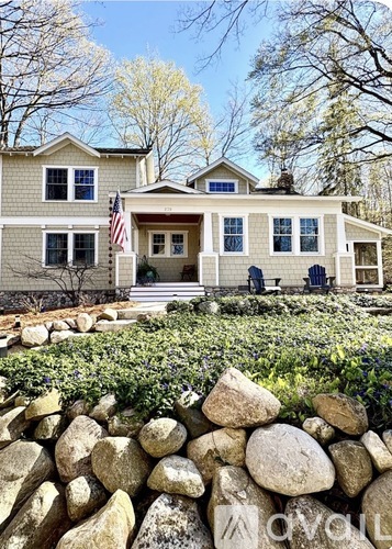 A house with a stone wall in front.