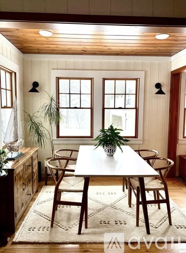 A dining room with a white table and chairs.