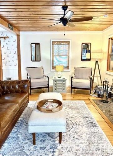 A living room with a brown leather couch and a white ottoman.