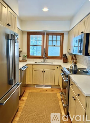A kitchen with wooden cabinets and a refrigerator.
